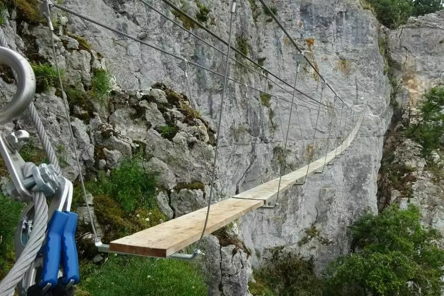 une passerelle passe en surplomb du vide d'un point à l'autre d'une des falaises de saint antonin noble val en occitani