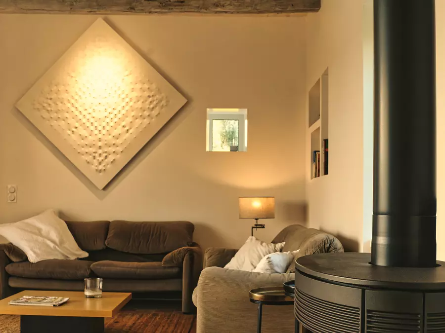 le coin salon du gite la cubane proche de saint antonin noble val ; deux canapés, une table basse, un tableau style castellani, un fenestron qui apporte de la lumière