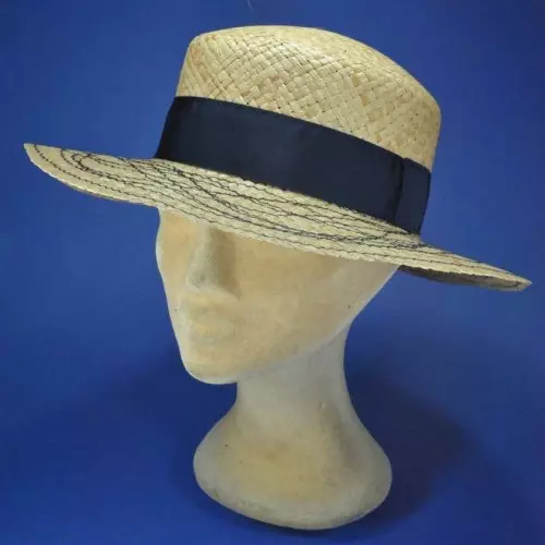 un canotier de femme, chapeau en paille entouré d'un ruban sombre, posé sur une tête de mannequin