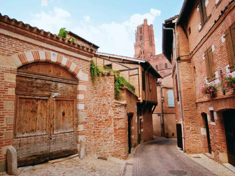 le vieil albi : maisons en briques, certaines avec un colombage et dans le fond le clocher de la basilique sainte cécile