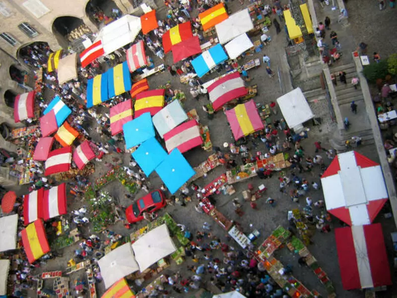vue aérienne de la place notre dame de villefranche de rouergue dans l'aveyron, région occitanie ; la place est couverte par les toiles de kiosque des marchands, donnant un caractère très coloré à l'ensemble